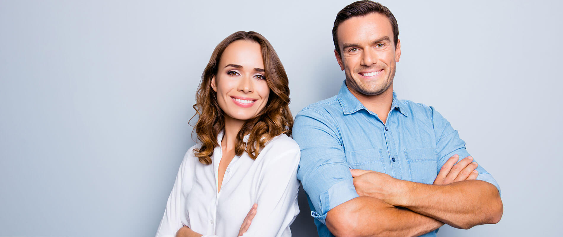 He vs she happy together. Close up portrait of attractive, caucasian, lovely, cute, adult couple in casual outfit looking at camera standing with crossed arms over grey background